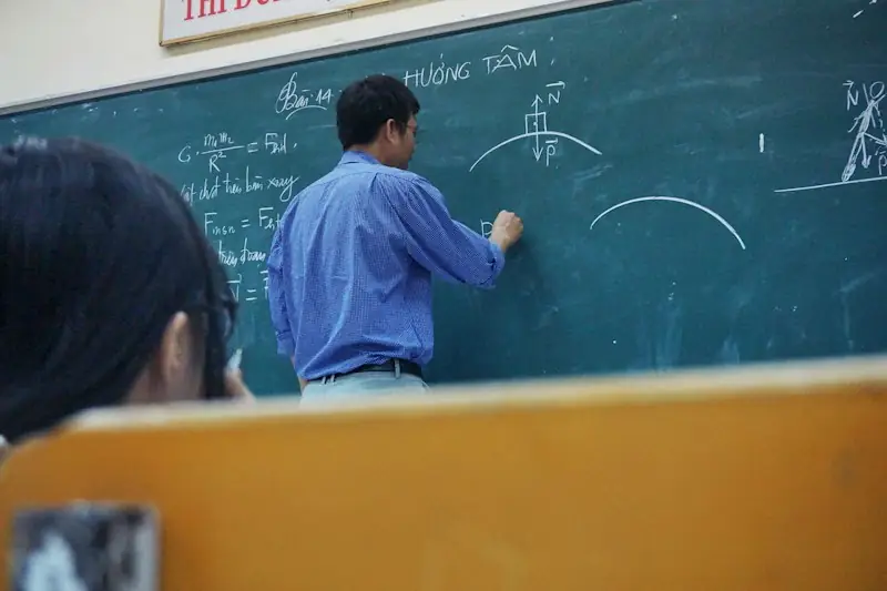 A teacher explaining a lesson at the blackboard