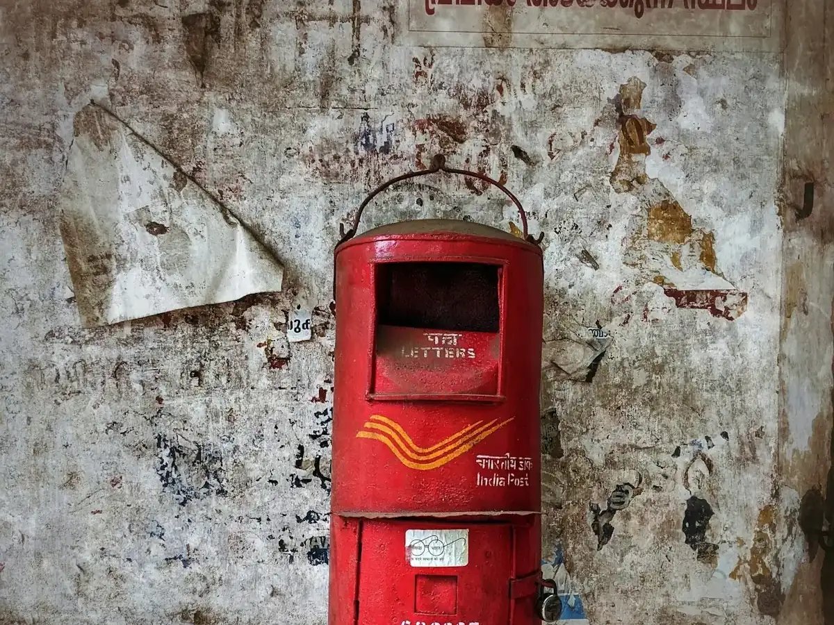 A red India Post letter box on a wall